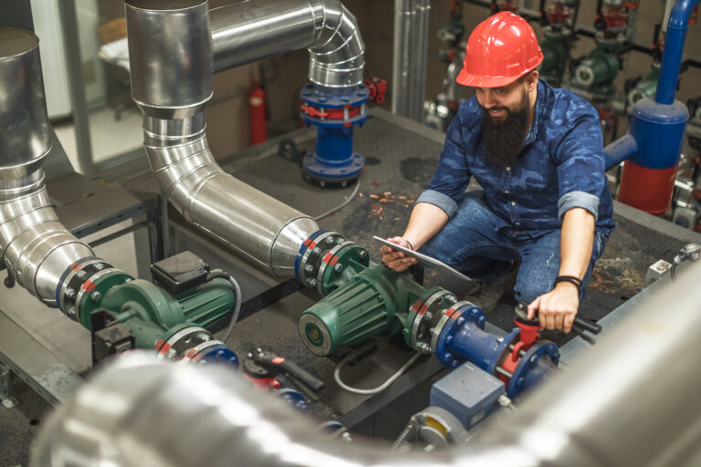 man servicing steam boiler