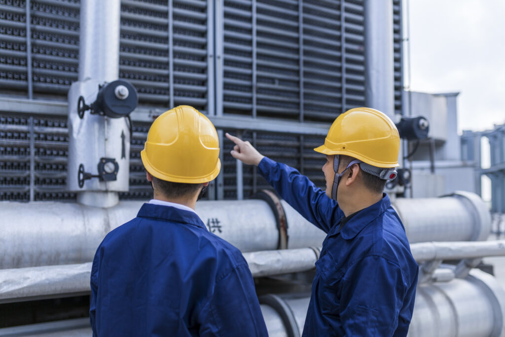 Two Engineer Colleagues Examining Cooling Tower Equipment