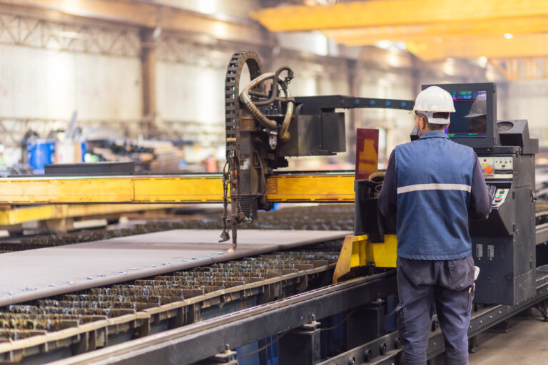 Steel worker on CNC plasma cutter machine